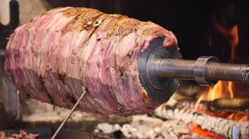 Meat roasting on a spit over open fire in a rustic setting video