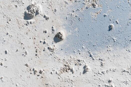 Rough, textured surface with light and dark patches photo