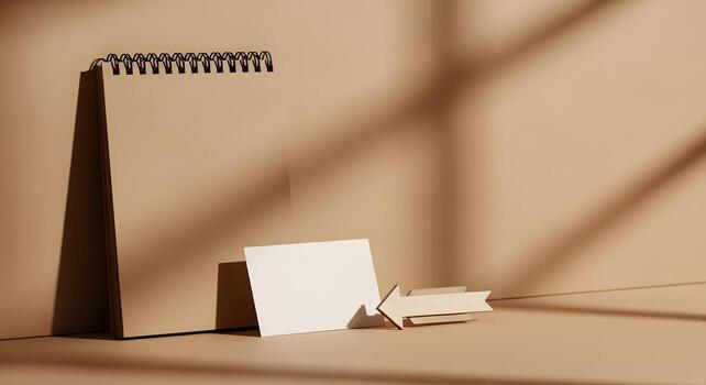 Elegant minimalist workspace with blank notebook and card, highlighted by natural light and artistic shadows, symbolizing new ideas, planning, and eco-friendly design concepts photo