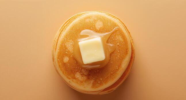 Stack of Golden Pancakes with Syrup and a Square of Butter on a Light Brown Backdrop. photo