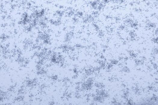 Abstract pattern of delicate snow and scattered ice crystals creating a beautiful frosty winter texture on a cold surface, ideal for seasonal graphic design backgrounds photo