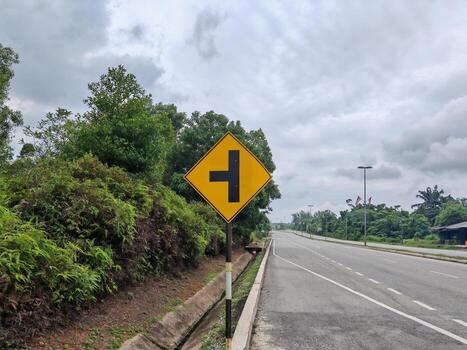 Traffic sign T junction on the road with cloudy sky background photo