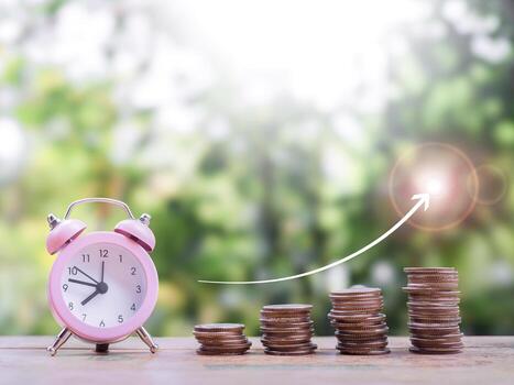 Pink alarm clock and stack of coins with arrow rising up. The concept of saving money for manage time to success business in the future photo