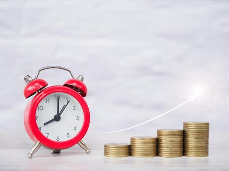 Red alarm clock and stack of coins with arrow rising up. The concept of saving money for manage time to success business in the future photo