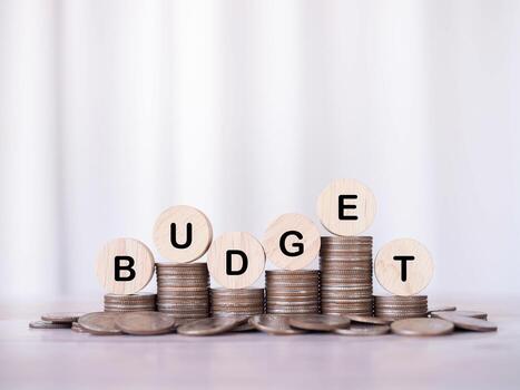 Wooden blocks with the word BUDGET on stack of coins. Concept about budget planning and allocation photo