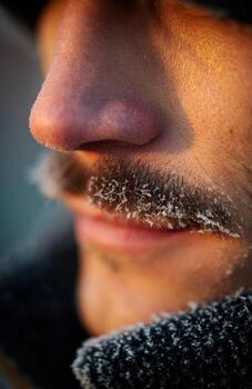 Man's face with frozen mustache in cold winter photo