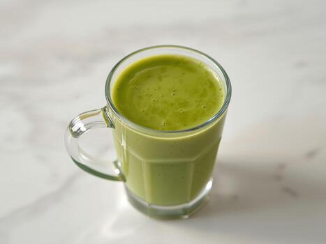 Green Elixir in Glass A Study of Texture, Color, and Form on a Marble Surface. photo