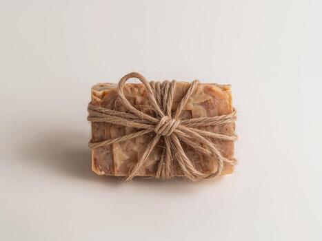 Natural Rectangular Object Wrapped with Twine, Displayed on a Plain White Surface. photo