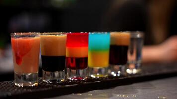 rad av färgrik skiktad skott med bartender tillsats grädde video
