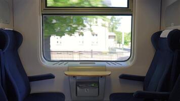 tömma blå tåg säten med tabell förbi fönster och godkänd träd video