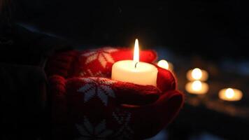 halten ein Kerze im Winter Handschuhe während ein dunkel Abend Mahnwache draußen video