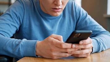 man använder sig av smartphone på tabell under de dagtid video