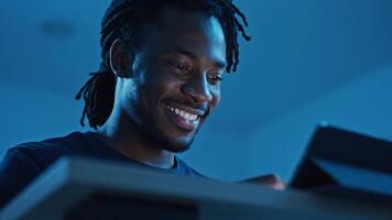 man med dreadlocks leende medan använder sig av en läsplatta i de kväll video