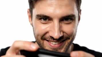 man leende medan använder sig av hans telefon på en vit bakgrund video