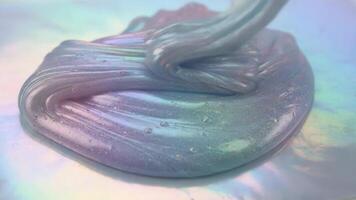 regnbågsskimrande slem demonstrera dess textur och form på holografiska yta video
