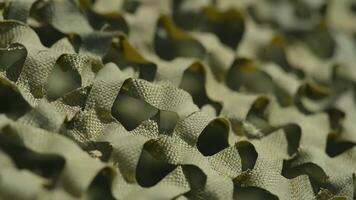 närbild av solbränna kamouflage nät tyg med upprepa Skära ut design i solljus video