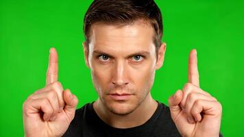 Man Points Upwards With Both Index Fingers Against Green Background video