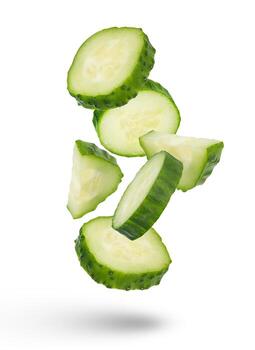 Slices of green cucumbers on a white isolated background. Slices of green cucumbers scatter in different directions. The concept of a delicious addition to a salad. photo