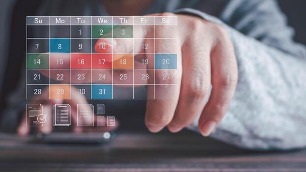 A person's finger points to the 10th on a digital calendar overlay on a smartphone. This signifies scheduling an appointment or managing tasks on a wooden desk. photo