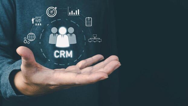 A businessman's hand holds a virtual CRM interface with icons for business management and customer relations. The concept illustrates technology in client strategy and data organization. photo