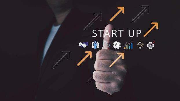 A man in a suit shows a thumbs up to a futuristic display with START UP text and business icons like AI and analytics symbolizing a new venture and success. photo