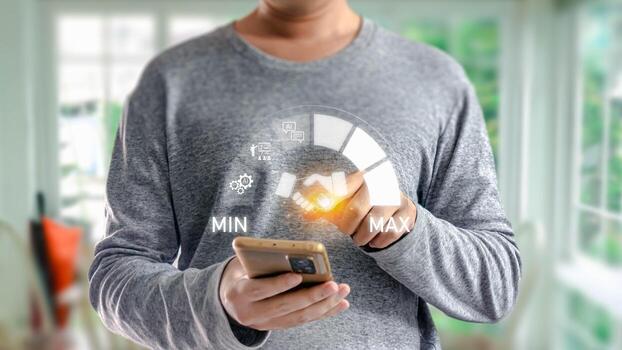Man holding smartphone with futuristic interface showing handshake icon on a meter, symbolizing successful digital agreement or partnership through modern technology. photo