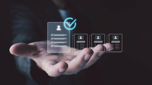 A person's hand is extended forward, displaying a series of glowing digital profiles and checklists, with one prominently selected. photo