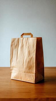 Brown Paper Bag Placed on Wooden Table With Plain Background photo