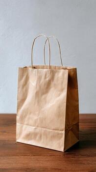 Brown Paper Bag Placed on Wooden Table With Plain Background. photo