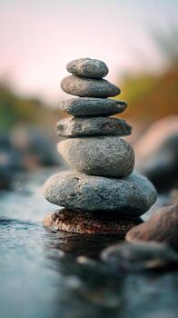 Stacked Stones Balanced Carefully in a Tranquil River Setting During Golden Hour photo