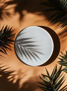 Decorative Plate Surrounded by Palm Leaves on Warm Orange Background photo