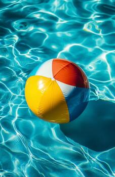 Colorful Beach Ball Floating on Clear Water in Summer Pool Scene photo
