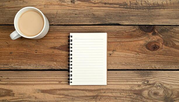 Top View of Coffee Cup and Spiral Notebook on Rustic Wooden Table for Creative Work Study or Planning photo