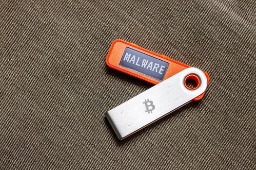 hardware Bitcoin wallet in with Malware message on screen photo