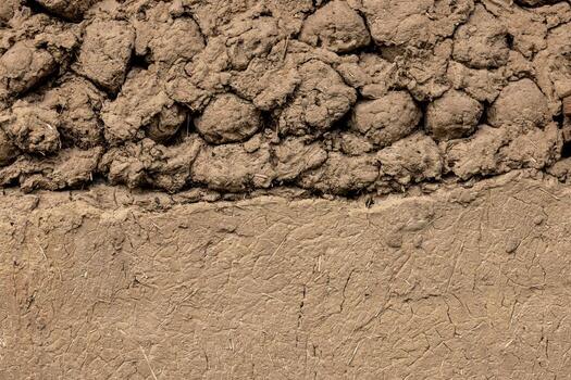 Rustic adobe wall texture partially plastered with same material photo