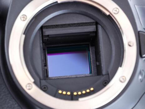 Close-up of a DSLR camera with exposed image sensor in studio setting photo