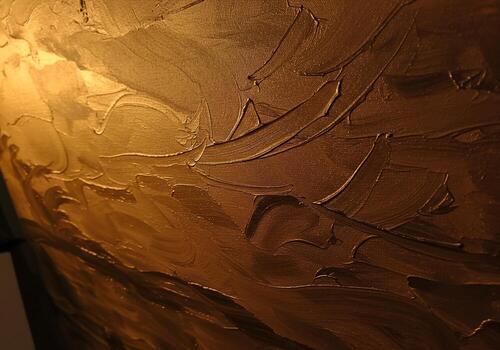 Textured golden paint strokes on canvas creating an abstract warm and dimensional surface photo