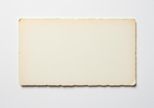 Aged paper with deckle edges soft cream color and subtle texture on a white background photo