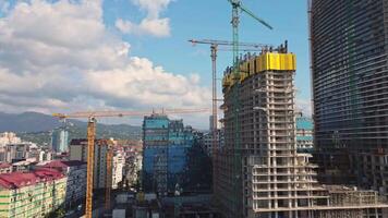 dynamisk hyperlaps av hög stiga byggnad konstruktion i batumi med kranar, förstärkt betong strukturera, och oavslutat skyskrapa ram video
