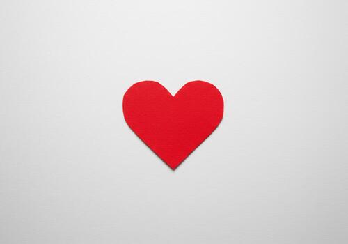 Red Paper Heart Symbol on White Background photo