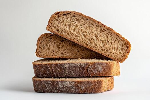 Stacked rye bread slices sit against a plain white backdrop creating texture and shadow photo