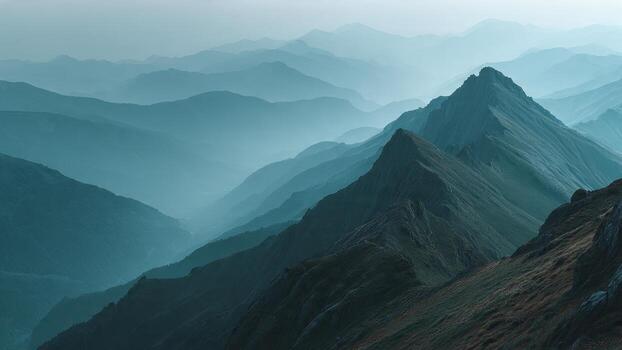 Layers of mist shrouded mountain peaks receding into a hazy blue sky landscape photo