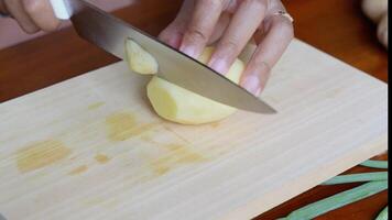 en personens hand är skärande rå potatisar in i tunn cirklar använder sig av en skarp kniv fri videoklipp video