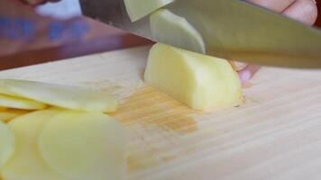 färsk potatisar är varelse skära förbi någon in i tunn bitar använder sig av en skarp kniv fri videoklipp video