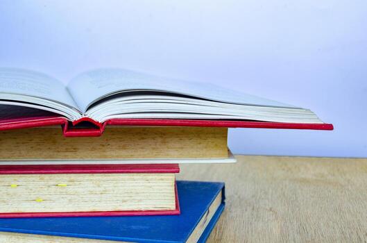 A dynamic arrangement of books stacked and one half open with pages mid turn creating a motion effect. photo