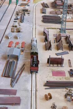 Small model train navigating through an industrial layout with various materials and structures photo