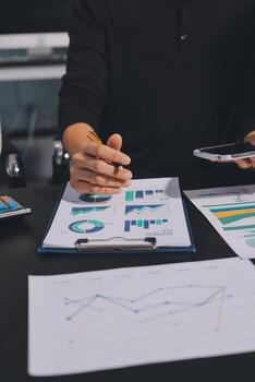 Hands analyzing data sheets and graphs photo