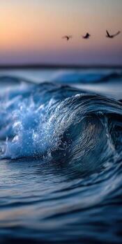 A wave in the ocean with birds flying above photo