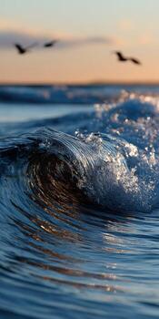 A wave in the ocean with birds flying over it photo