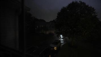 vicino su Visualizza a partire dal il finestra con montanti e bicchiere con gocce di pioggia. lampeggiante alleggerimento di temporale riflettendo nel il bicchiere. vicino su tiro a partire dal dentro il edificio video